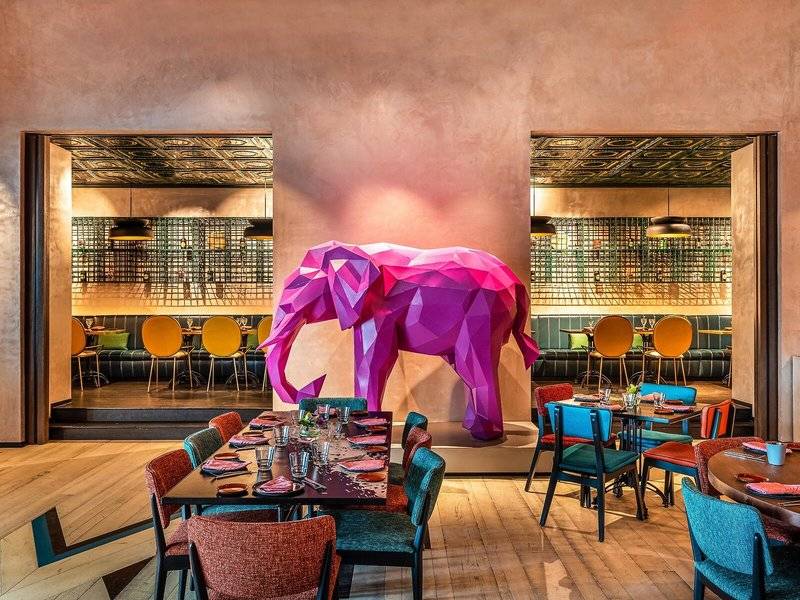 Inneneinrichtung des Rixos Gulf Hotel Doha mit einer großen rosa Elefanten-Skulptur im Vordergrund.