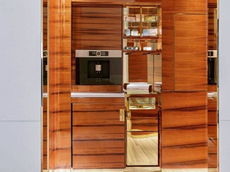 Innenansicht der Küche im Fairmont Doha mit Holzschränken und Edelstahlgeräten.