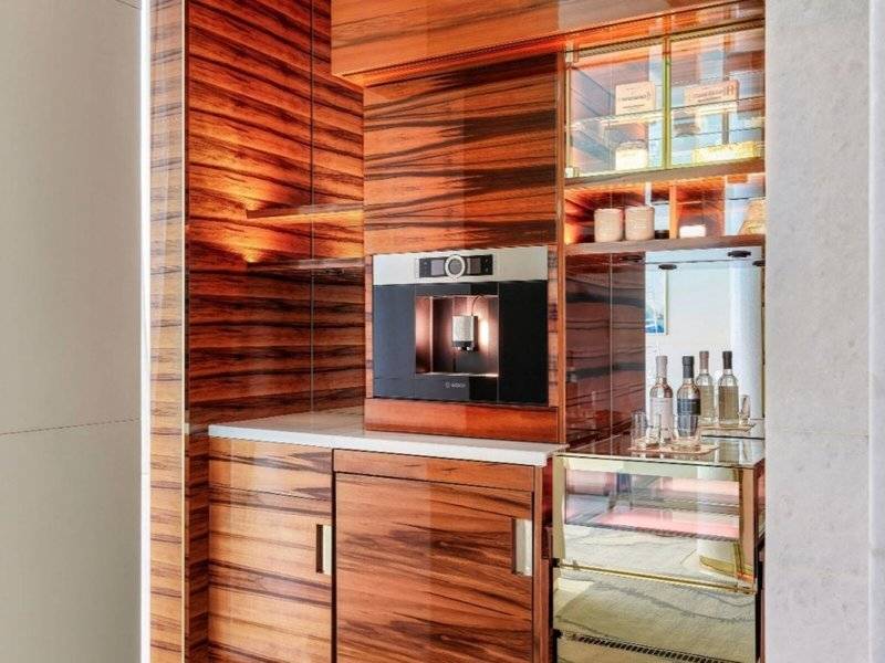 Zimmer im Fairmont Doha mit Holzschränken und Kaffeemaschine.