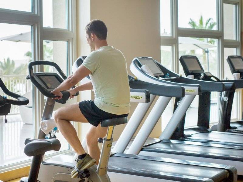 Fitnessstudio im Four Seasons Hotel Doha mit einem Mann auf einem Spinnrad.
