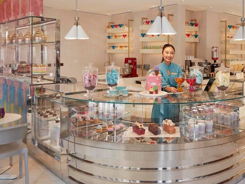 Eine Verkäuferin im Mandarin Oriental Doha präsentiert eine Auswahl an Desserts.