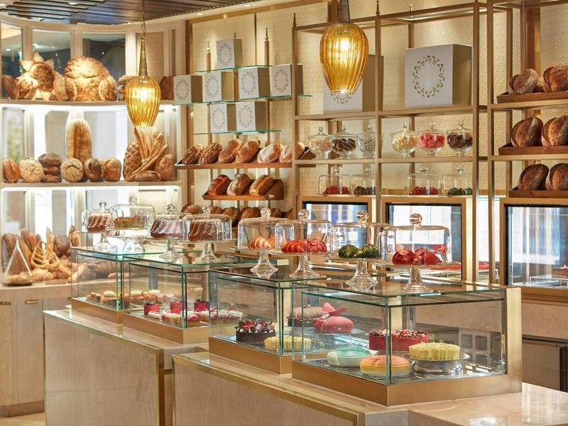 Patisserie im Mandarin Oriental Doha mit Brot und Gebäck hinter Glasvitrinen.
