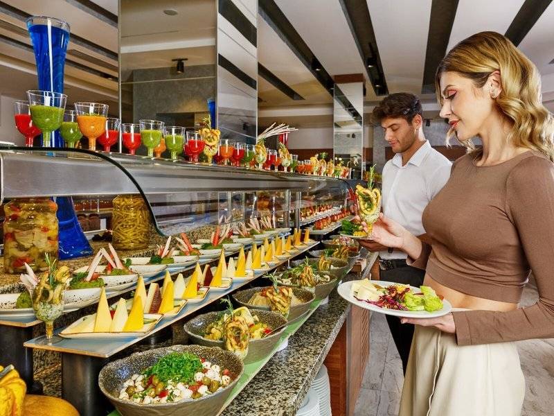 Paar genießt von einer Auswahl an Speisen an einem Buffet im Grand Park Lara Hotel