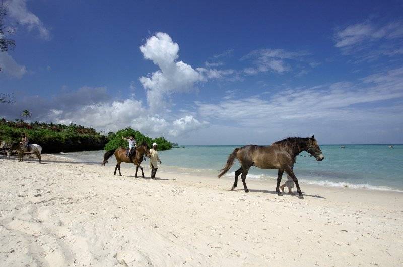 Menschen reiten auf Pferden am Strand des Sea Cliff Resort & Spa