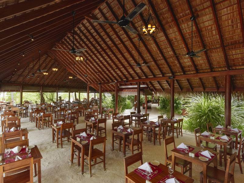 Innenbereich eines Restaurants im Summer Island Maldives Hotel mit gedeckten Tischen und Stühlen.