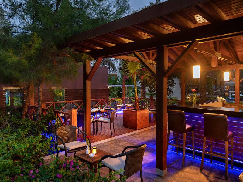 Terrasse des Turquoise Hotels mit beleuchteten Stühlen und Bar.
