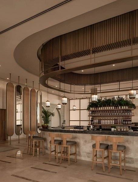 Barbereich im JAZ Riviera Hotel mit Holzstühlen und runden Deckenverkleidungen.