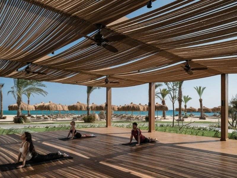 Yoga-Übungen auf der Terrasse des JAZ Riviera Hotels mit Blick auf den Strand und das Meer.