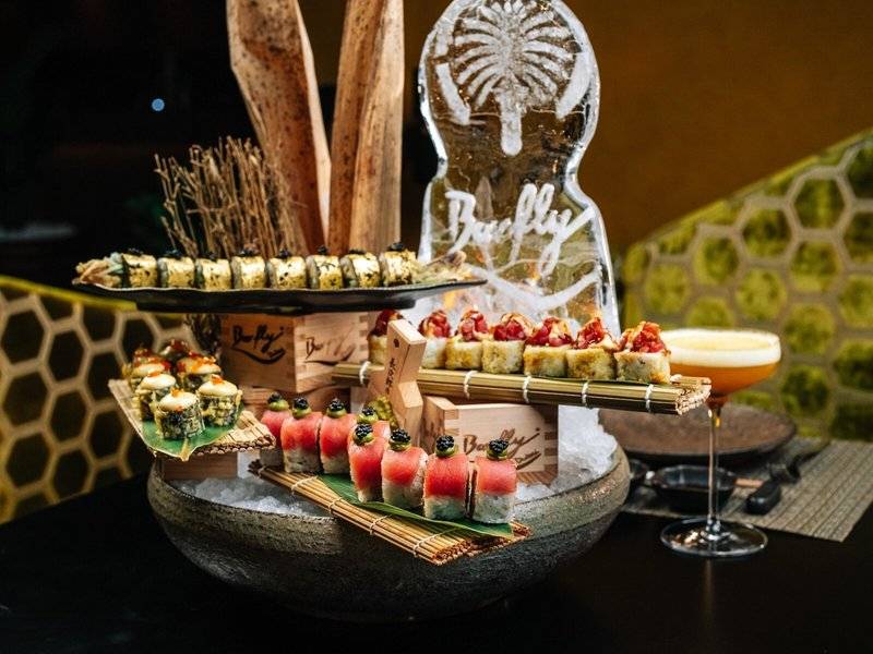 Sushi-Buffet im Hilton Dubai Palm Jumeirah mit verschiedenen Gerichten auf mehreren Ebenen.