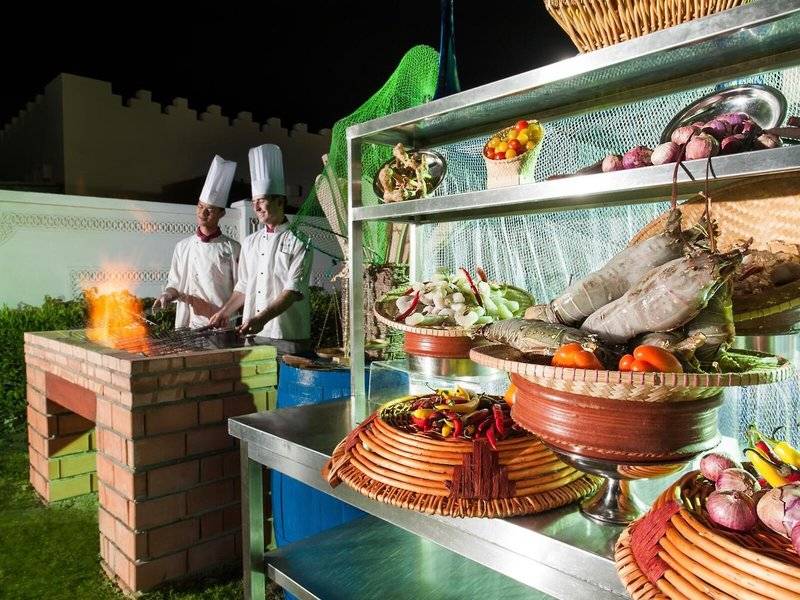 Grillstation im Sealine Beach Hotel mit Köchen und verschiedenen Gemüsesorten