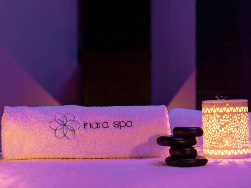 Ein Handtuch und ein Becher mit Steinen im Inara Spa bei Nacht