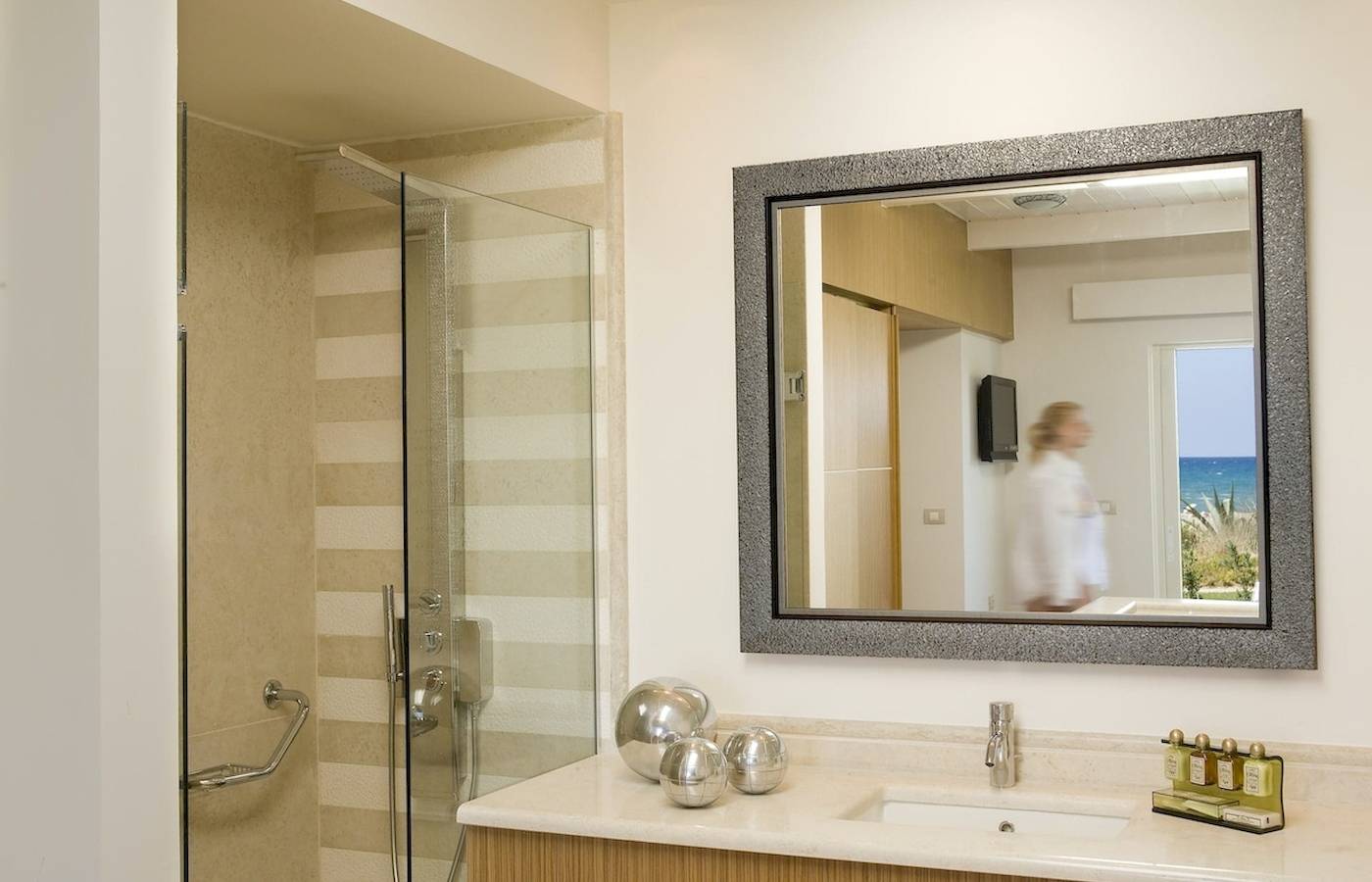 Badezimmer im Pilot Beach Resort mit Spiegel, Dusche und Meerblick.