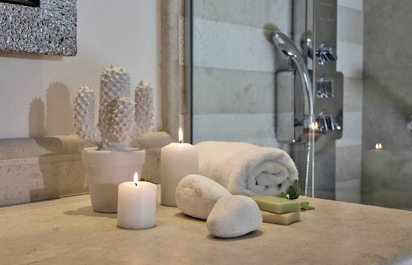 Badezimmer im Pilot Beach Resort mit Kerzen, Kaktus und Handtüchern.