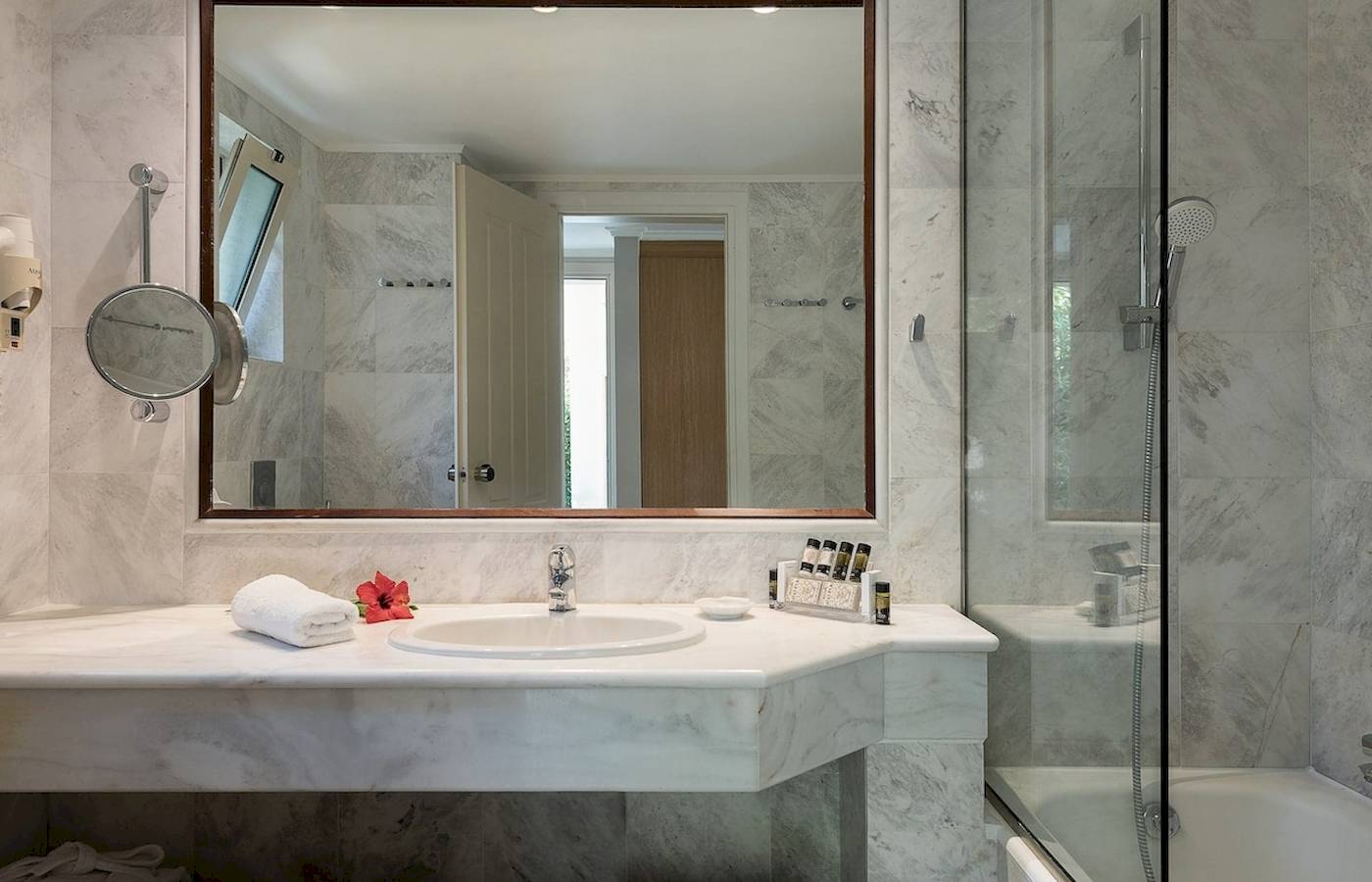 Badezimmer im Pilot Beach Resort mit großem Spiegel, Waschbecken und Badewanne.