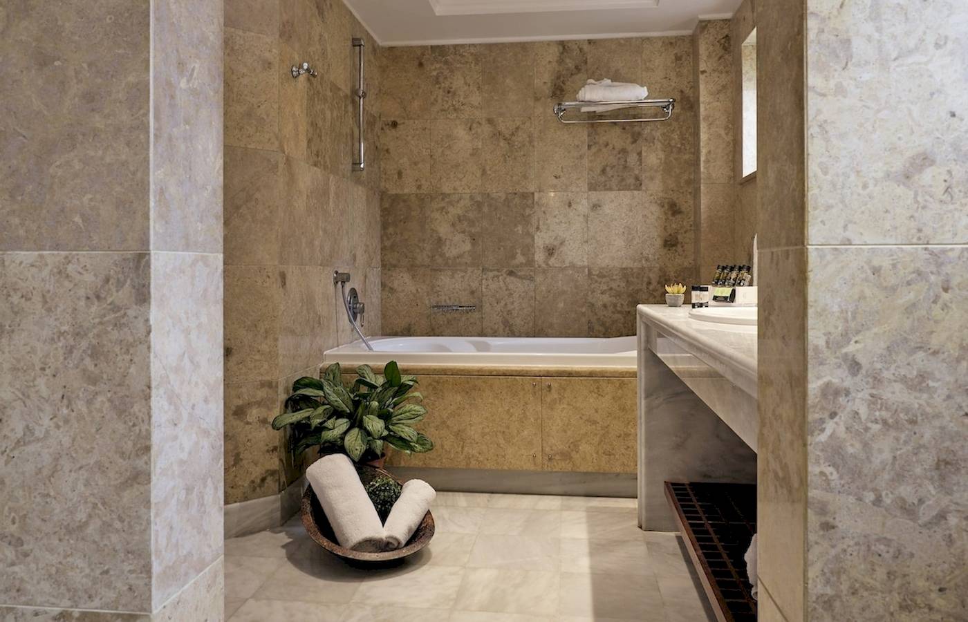 Ein Badezimmer im Pilot Beach Resort mit einer Badewanne, einer Pflanze und einem Waschbecken.