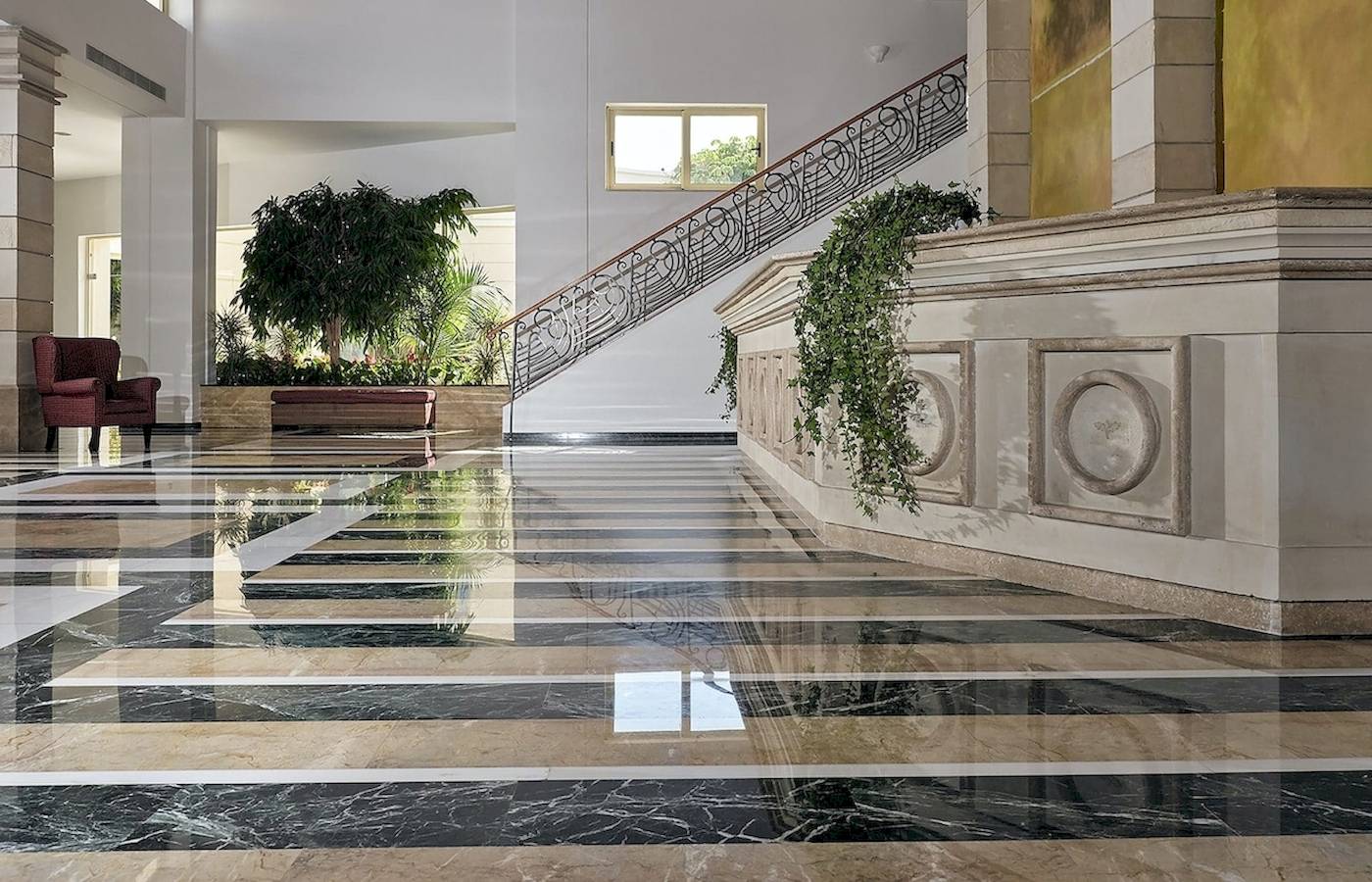 Foyer des Pilot Beach Resorts mit Marmorboden und geschwungener Treppe