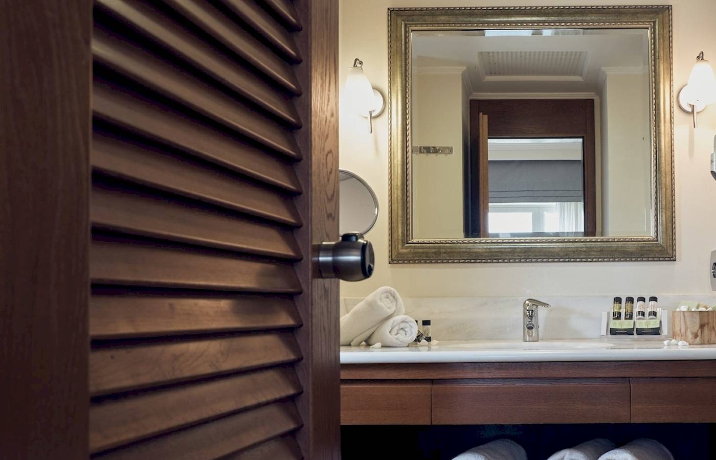 Badezimmer im Pilot Beach Resort mit Spiegel, Waschbecken und Handtüchern.