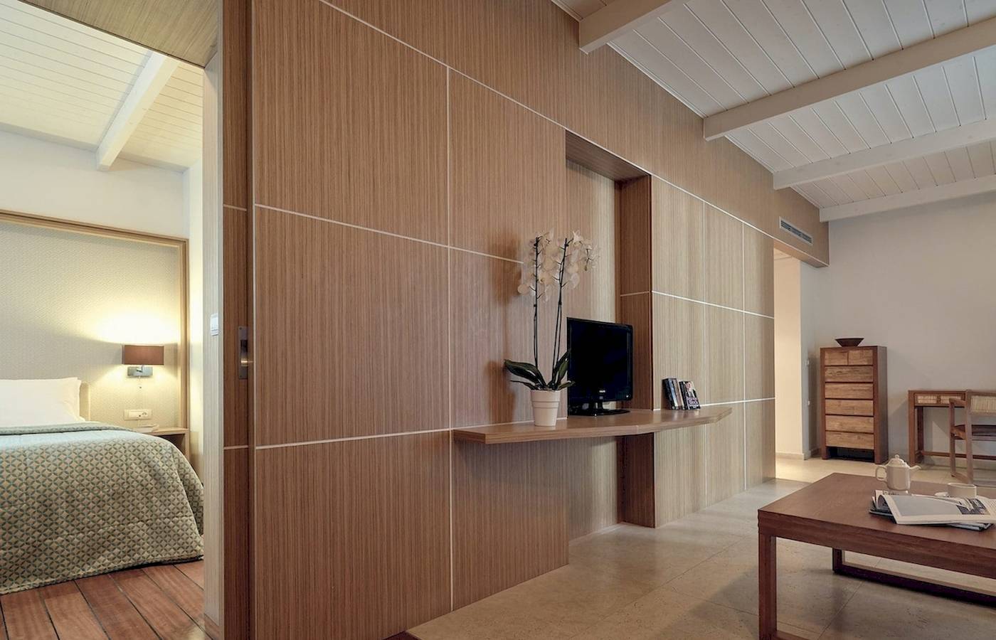 Innenansicht eines Hotelzimmers im Pilot Beach Resort mit Bett, Fernseher und Tisch