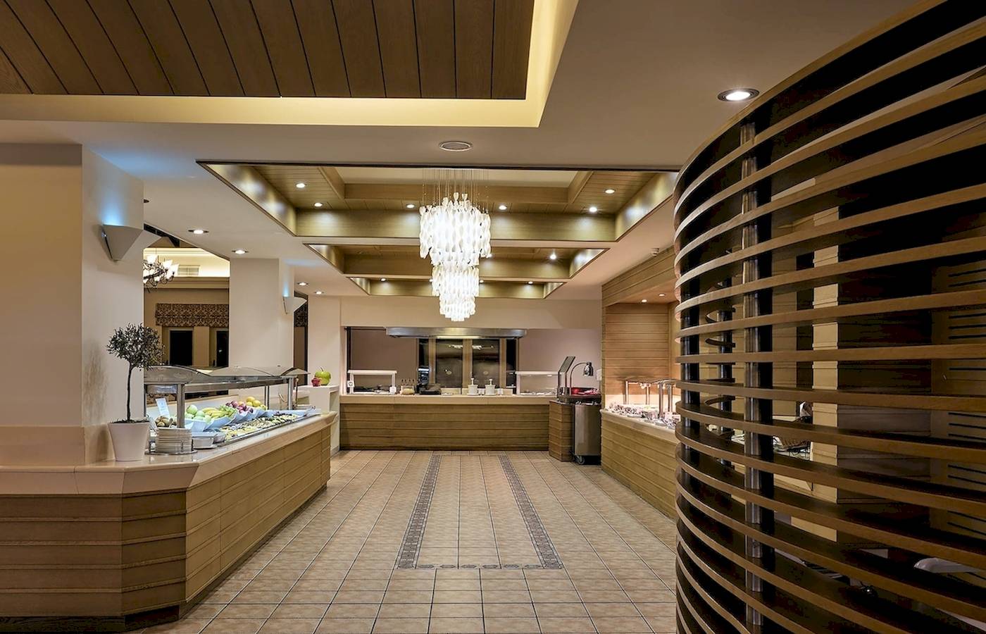 Innenbereich des Pilot Beach Resorts mit einem großen Buffet und einer geschwungenen Holzstruktur.