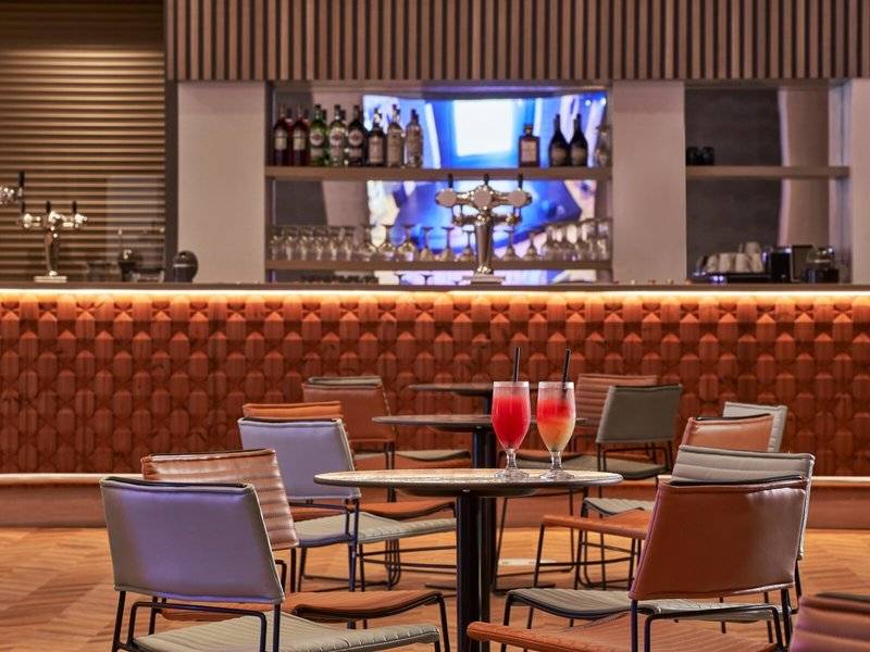Innenansicht der Bar im Mare Paphos Hotel mit Cocktails und braunen Lederstühlen.