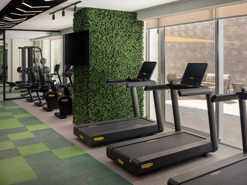 Fitness-Center im St. Regis Al Mouj Muscat Resort mit Laufbändern und Kraftgeräten.