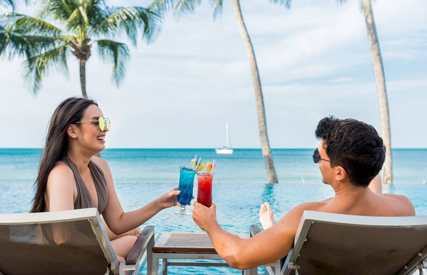 Ein Paar mit Cocktails am Pool im KC Grande Resort Koh Chang