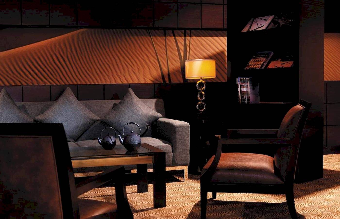 Interieur des Hotellobbys im Traders Hotel Qaryat Al Beri mit Sofa, Teekannen und Bücherregal.
