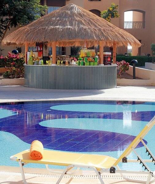 Pool-Bar im Lemon & Soul Garden Makadi mit einem gelben Liegestuhl und einem Handtuch.