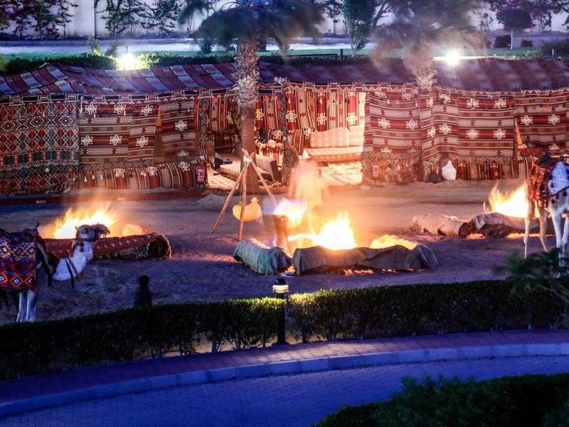 Bei Nachtaufnahme des Lemon & Soul Garden Makadi mit Feuerstellen und Kamelen.