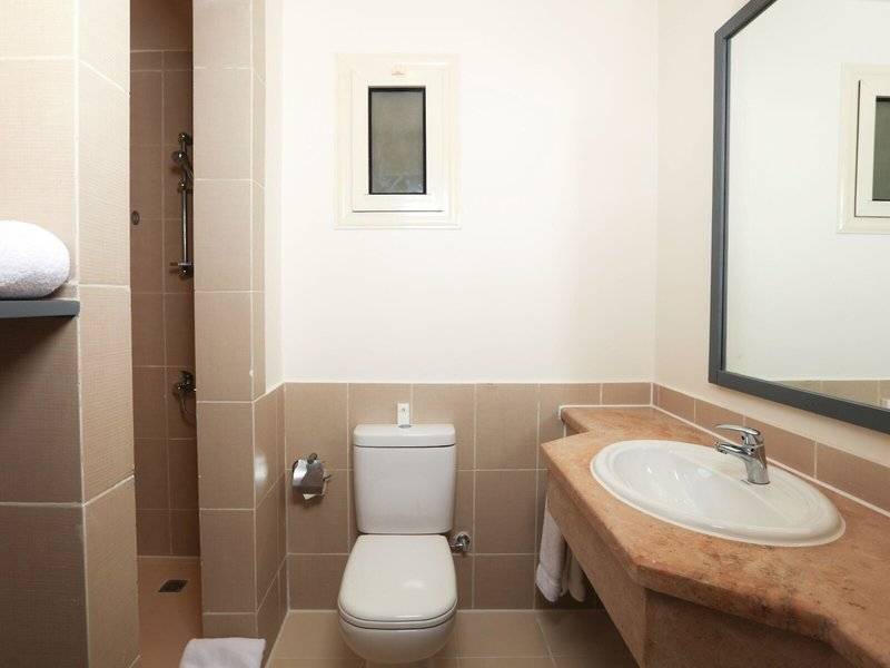 Badezimmer im Lemon & Soul Garden Makadi Hotel mit Toilette, Waschbecken und Spiegel.