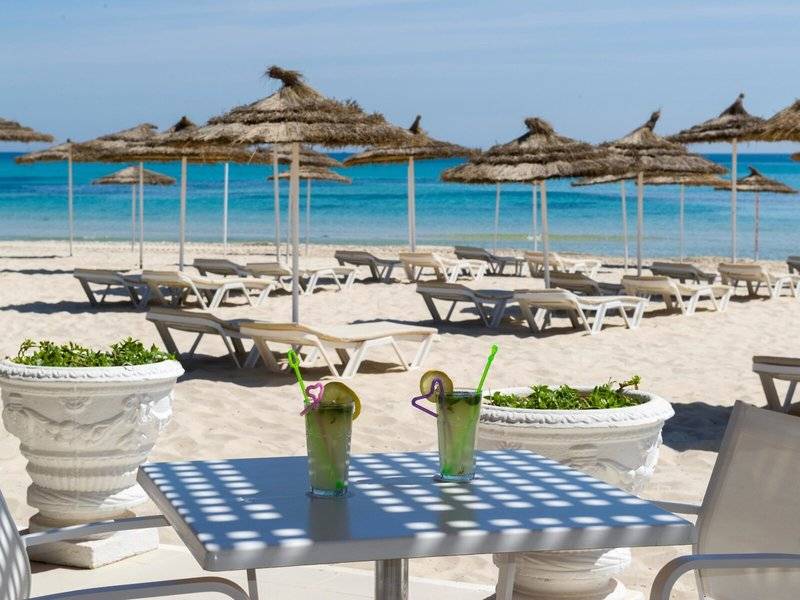 Strand mit Sonnenliegen und Getränken im JAZ Tour Khalef Hotel.