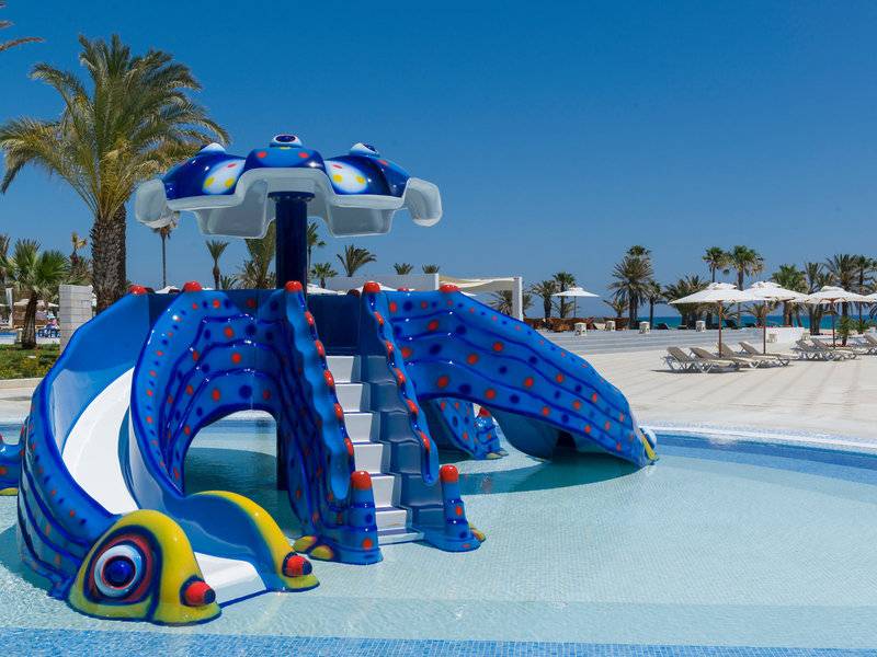 Wasserrutsche im Poolbereich des JAZ Tour Khalef Hotels mit bunten Farben und einem sommerlichen Hintergrund.