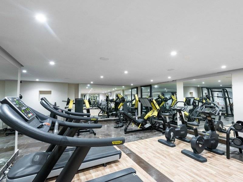 Fitnessstudio im Iberostar Selection Kuriat Palace mit Laufbändern und Kraftgeräten.