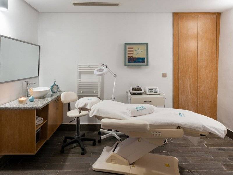 Spa-Behandlungsraum im Iberostar Selection Kuriat Palace mit Liege, Waschbecken, Lampen und dekorativen Elementen.