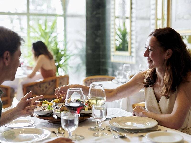 Paar am Tisch in einem Hotelrestaurant, sie genießen ihr Essen und Getränke.