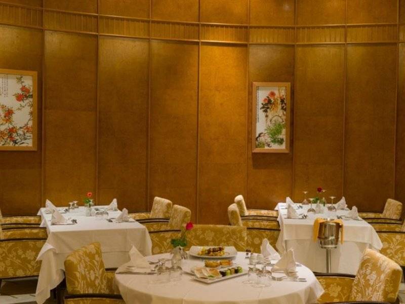 Speisesaal des Iberostar Selection Kantaoui Bay mit gedeckten Tischen und dekorativen Bildern an der Wand.