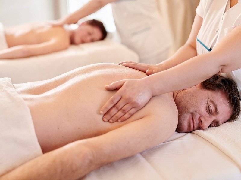 Massage im Iberostar Selection Kantaoui Bay Hotel: Ein Mann schläft auf einer Massageliege, während eine Therapeutin ihm eine Rückenmassage gibt.
