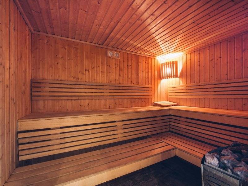 Eine Holzsauna im Iberostar Selection Diar El Andalous mit Holzbänken und einer Lampe an der Wand.