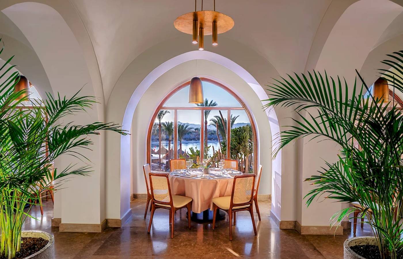 Innenbereich des Mövenpick Resorts El Quseir mit Esstisch und Blick auf das Meer