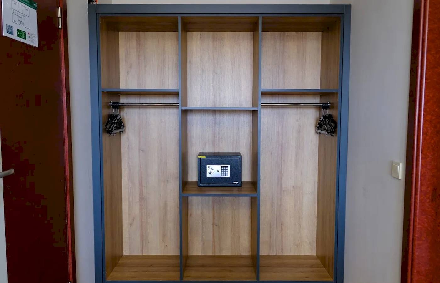 Ein Schrank im Club Wasa Holiday Village mit einem Safe auf dem mittleren Regal.