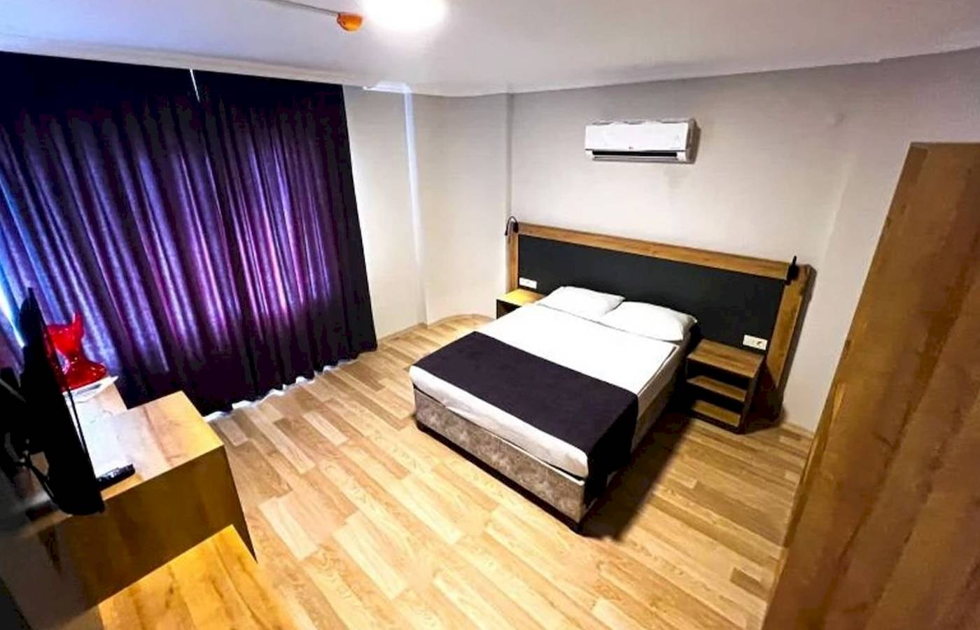 Ein Hotelzimmer im Club Wasa Holiday Village mit einem Bett, Fernseher und Klimaanlage.