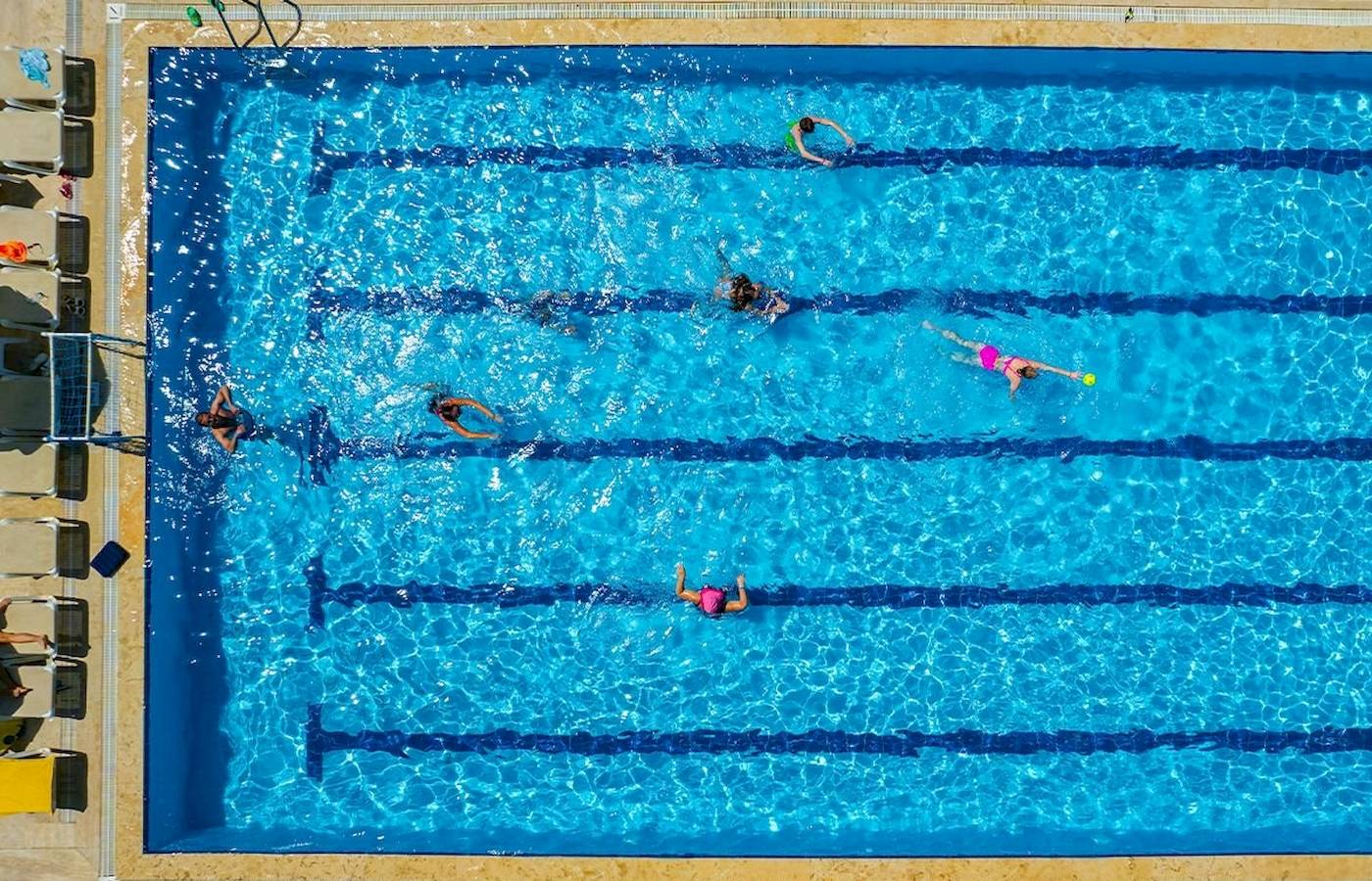 Mehrere Personen schwimmen im Club Wasa Holiday Village Schwimmbad.