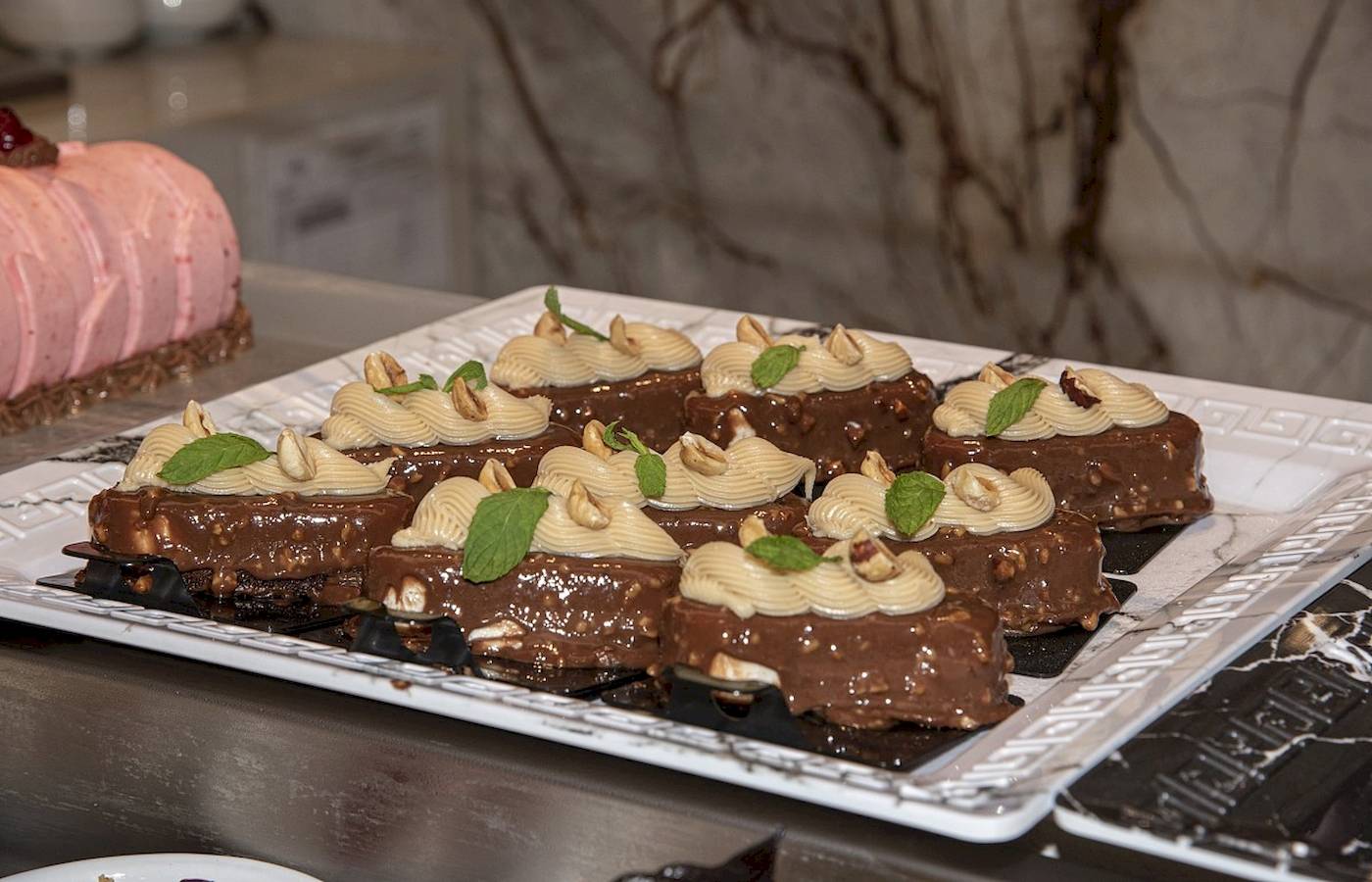 Mehrere Desserts auf einem Tisch im Vantaris Luxury Beach Resort.