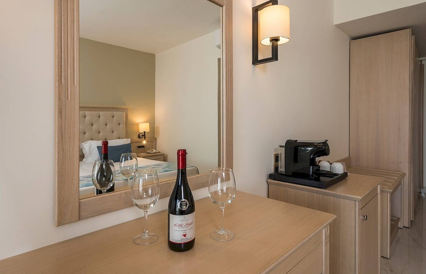 Zimmer im Vantaris Palace Hotel mit Bett, Weinflasche und Weingläsern