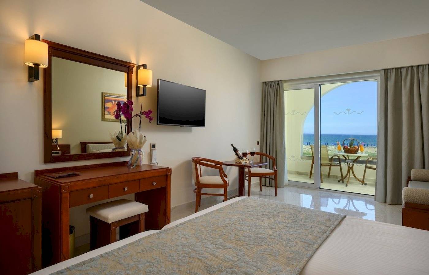 Vantaris Palace Hotel Zimmer mit Meerblick, Bett, Tisch, Fernseher und Balkon.