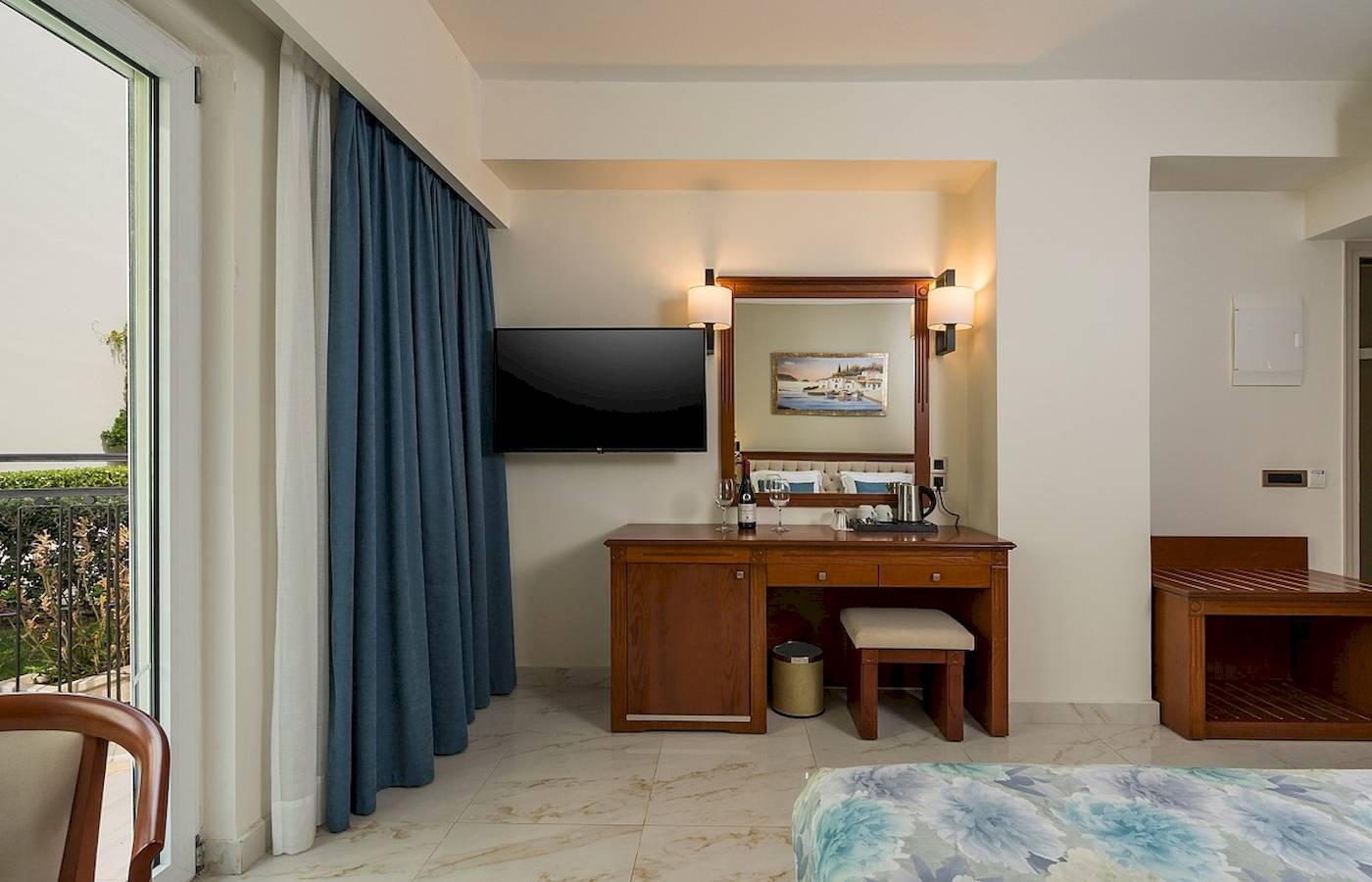 Hotelzimmer des Vantaris Palace mit Bett, Schreibtisch, Fernseher und Aussicht.