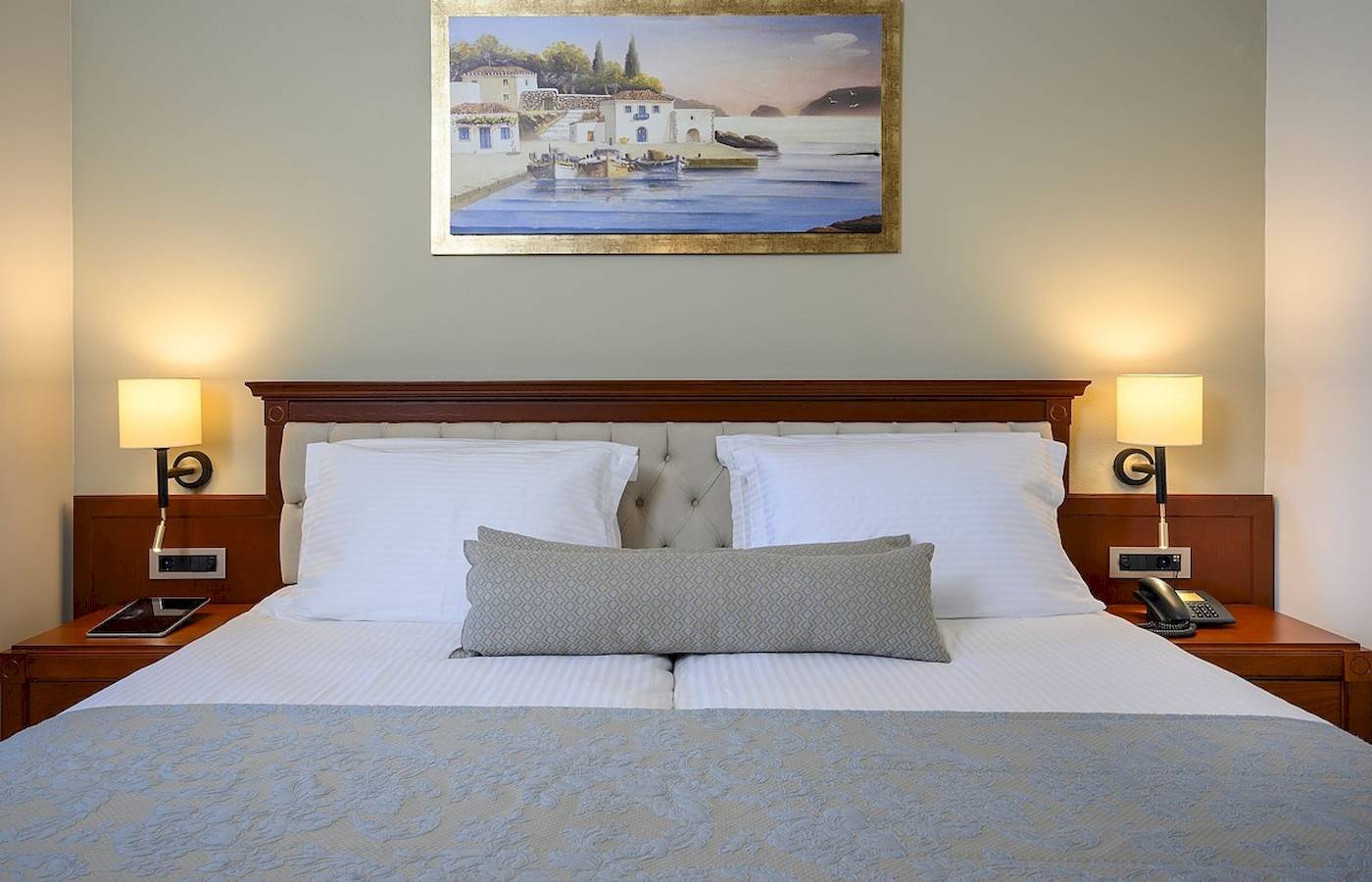 Bett im Vantaris Palace Hotelzimmer mit Dekor und Gemälde an der Wand