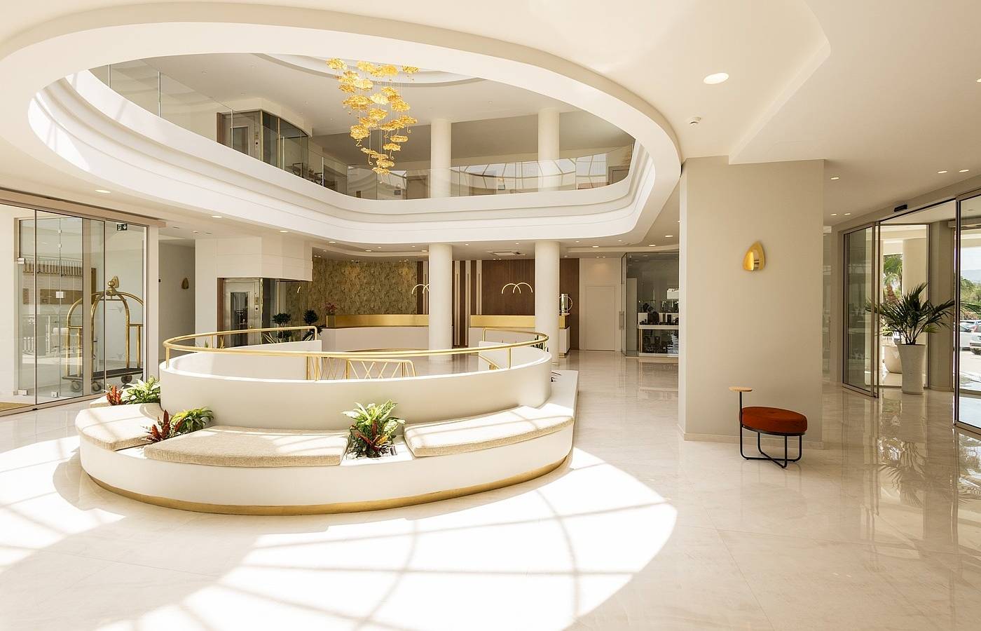 Vantaris Palace Lobby mit zentraler Sitzbank, goldenem Geländer und hängenden Lampen.
