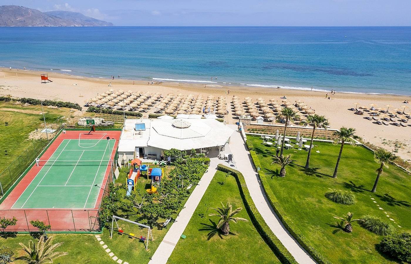 Luftaufnahme des Vantaris Palace Hotels mit Strand, Tennisplatz und Spielplatz