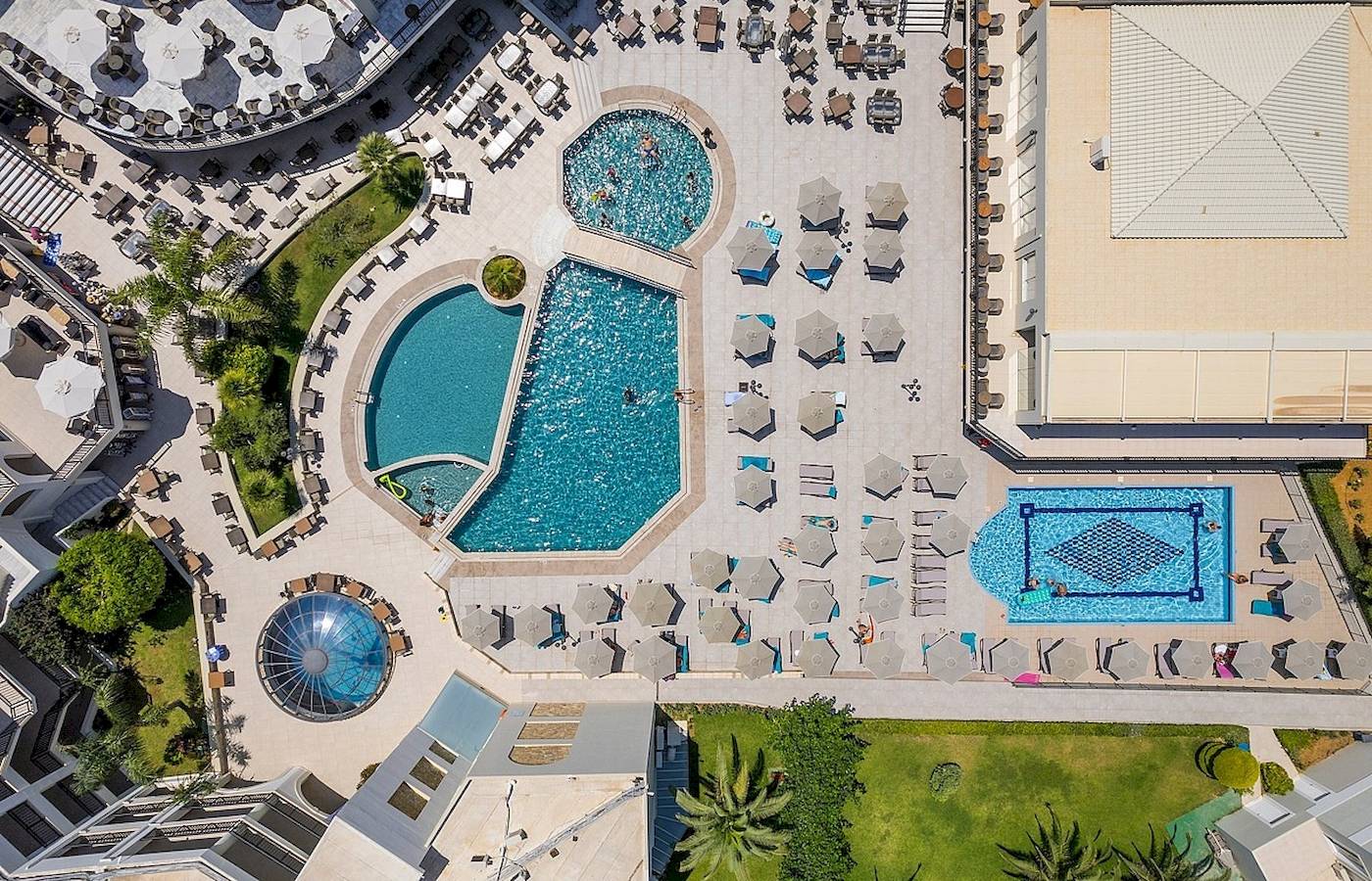 Luftaufnahme des Vantaris Palace mit mehreren Swimmingpools und Sonnenliegen.